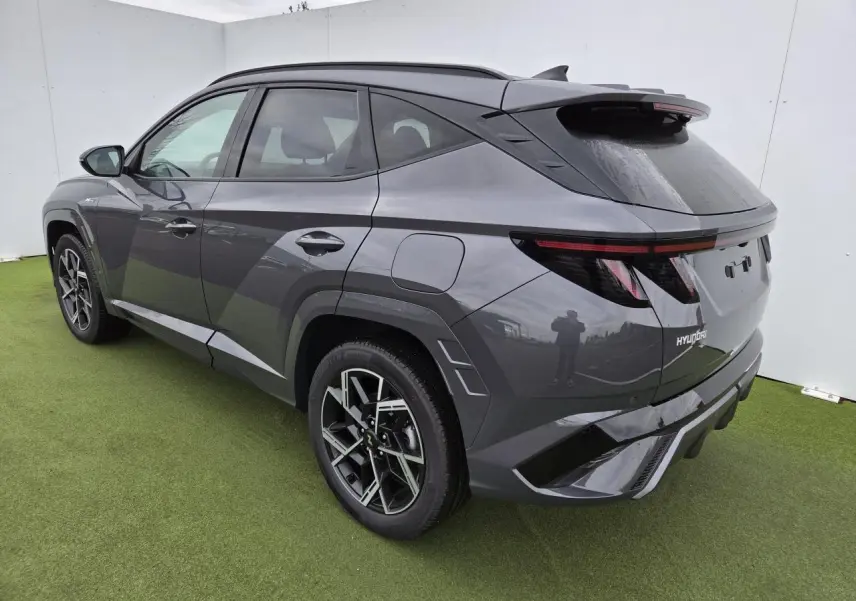 Vue 3/4 arrière droite du Hyundai Tucson 2025 gris métallisé avec jantes alliage et feux arrière LED en bandeau.