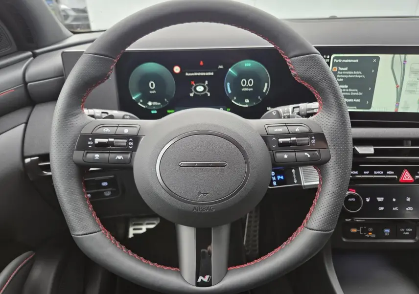 Vue rapprochée du volant sport N Line avec surpiqûres rouges et tableau de bord numérique du Hyundai Tucson 2025.
