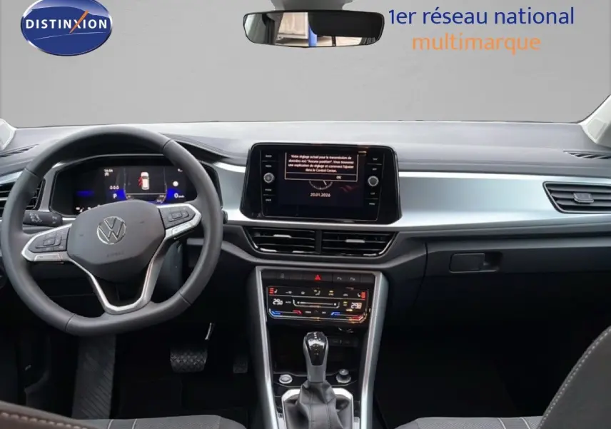 Vue intérieure avant du Volkswagen T-Roc noir Grenadilla, mettant en valeur le tableau de bord digital et la console centrale moderne.