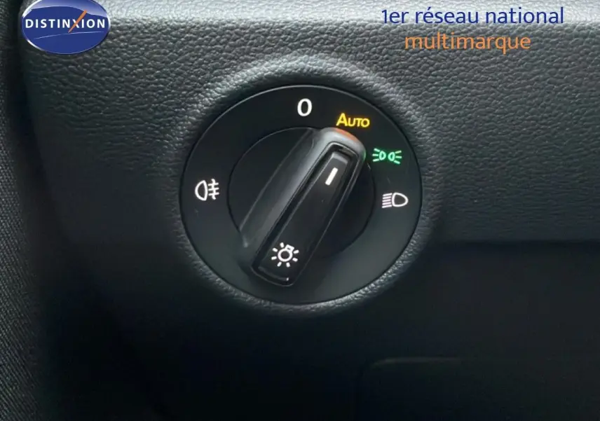 Gros plan sur le bouton de commande des phares du Volkswagen T-Roc 1.5 TSI noir Grenadilla, intérieur noir texturé.