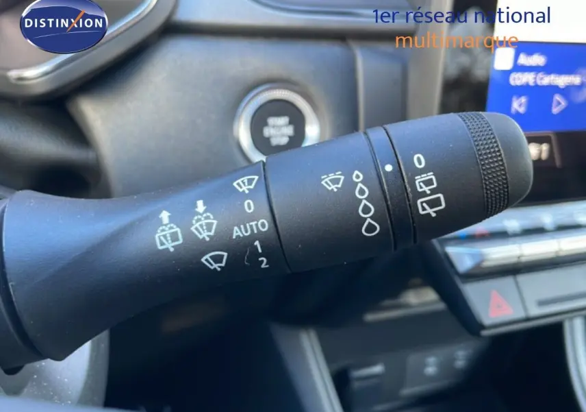 Gros plan sur la commande d’essuie-glace du Renault Captur 2025, intérieur noir avec écran tactile en arrière-plan.