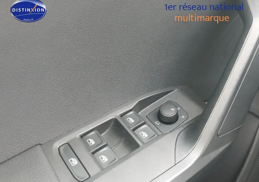 Gros plan sur les commandes de lève-vitres et réglage des rétroviseurs côté conducteur d'une SEAT Ibiza blanc Nevada.
