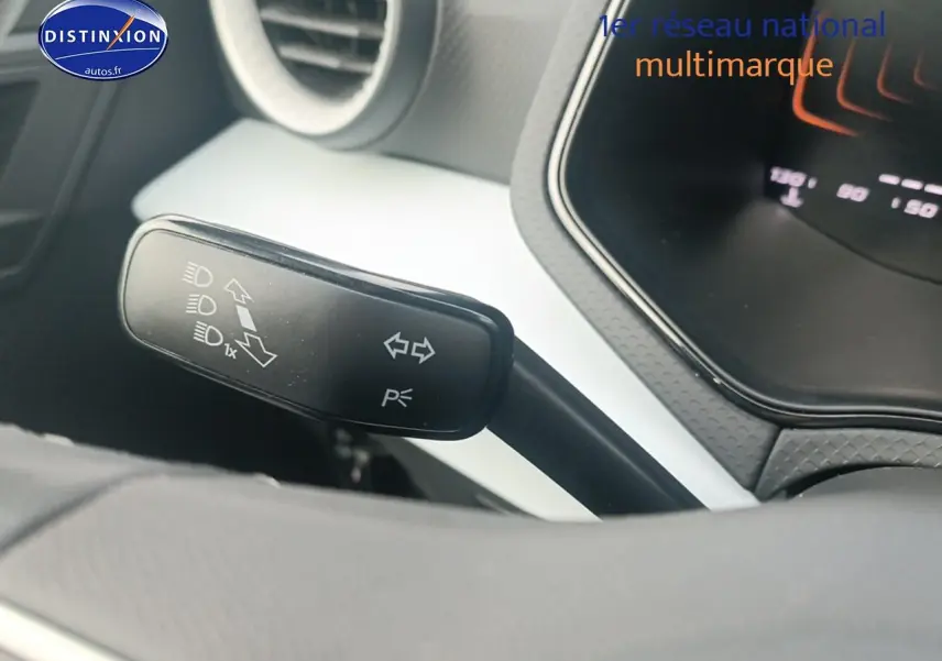 Gros plan sur la commande de clignotants noire à gauche du volant dans l’habitacle blanc et gris de la SEAT Ibiza 2025.