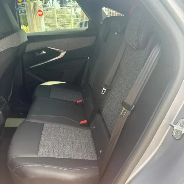 Vue intérieure côté droit des sièges arrière en tissu gris et cuir noir du Peugeot 3008 Hybrid 136 e-DCS6 Allure 2025 gris clair.