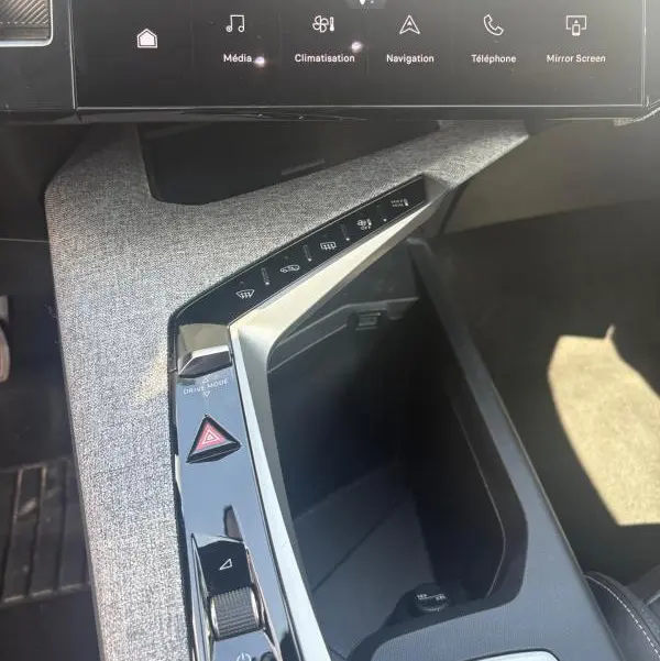 Vue rapprochée de la console centrale intérieure du Peugeot 3008 Hybrid 136 e-DCS6 Allure 2025, avec tissu gris clair et commandes tactiles.