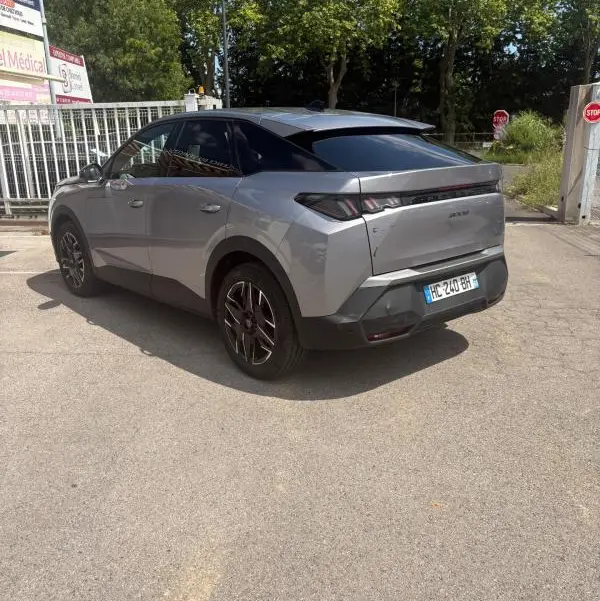 Peugeot 3008 Hybrid gris clair vue 3/4 arrière droit, toit noir et jantes alliage noires visibles.