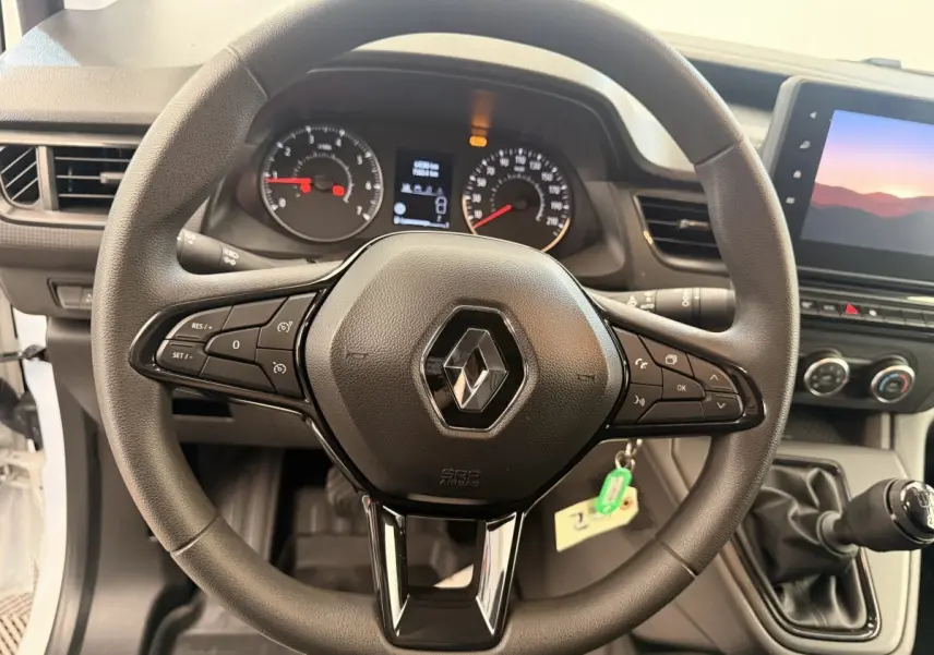 Vue rapprochée du volant multifonctions noir du Renault Kangoo 2023 avec tableau de bord et levier de vitesse manuel.