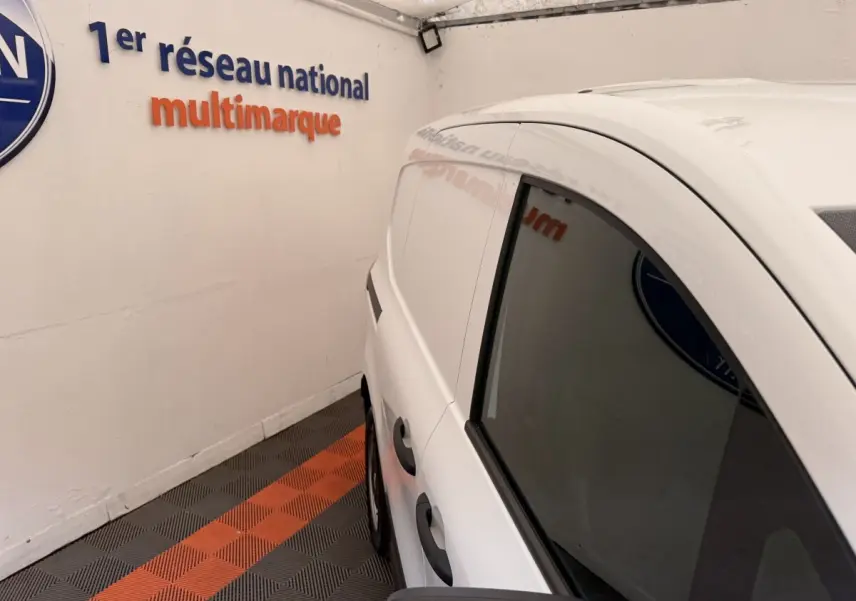Vue 3/4 arrière côté droit du Renault Kangoo blanc GD Confort 2023, avec vitres latérales teintées et poignées noires.