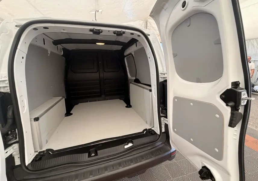 Vue arrière ouverte du Renault Kangoo blanc 2023, montrant l'espace de chargement vide et les parois grises.