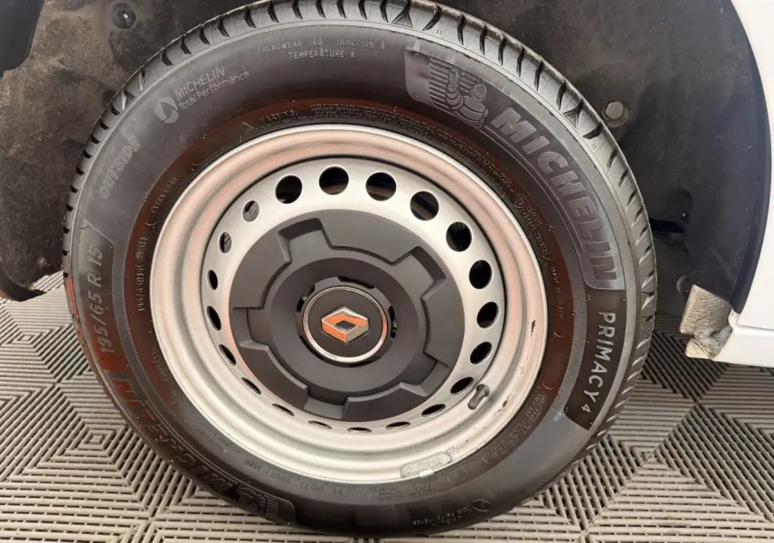 Gros plan sur la roue acier avec logo Renault centrale, montée sur un Renault Kangoo blanc visible partiellement.