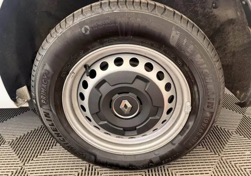 Gros plan sur la roue de secours Michelin avec jante acier et logo Renault au centre du Renault Kangoo blanc.