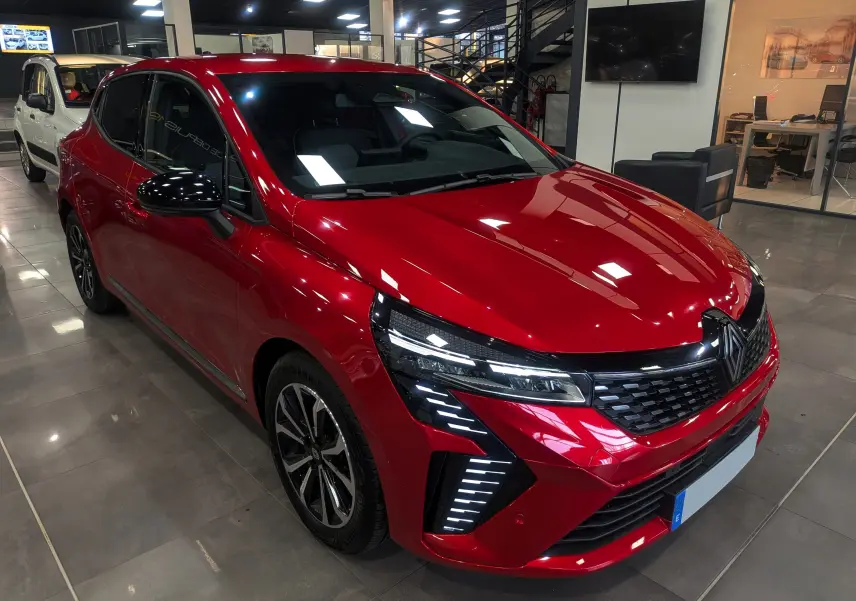 Renault Clio V Rouge Flamme vue 3/4 avant droit, avec feux LED distinctifs et jantes alliage biton.