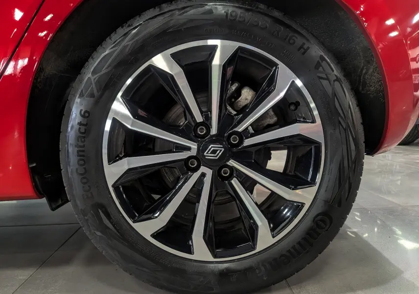 Gros plan sur la jante alliage bicolore de la Renault Clio V Rouge Flamme, avec logo Renault au centre.