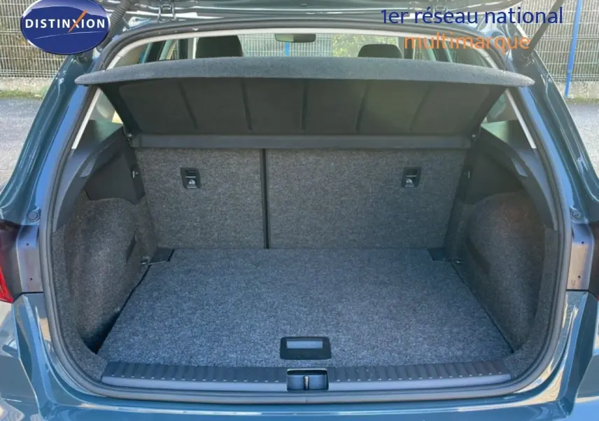 Coffre ouvert vu de l'arrière d'un SEAT Arona gris Fiord avec toit blanc, montrant un espace de chargement propre et spacieux.