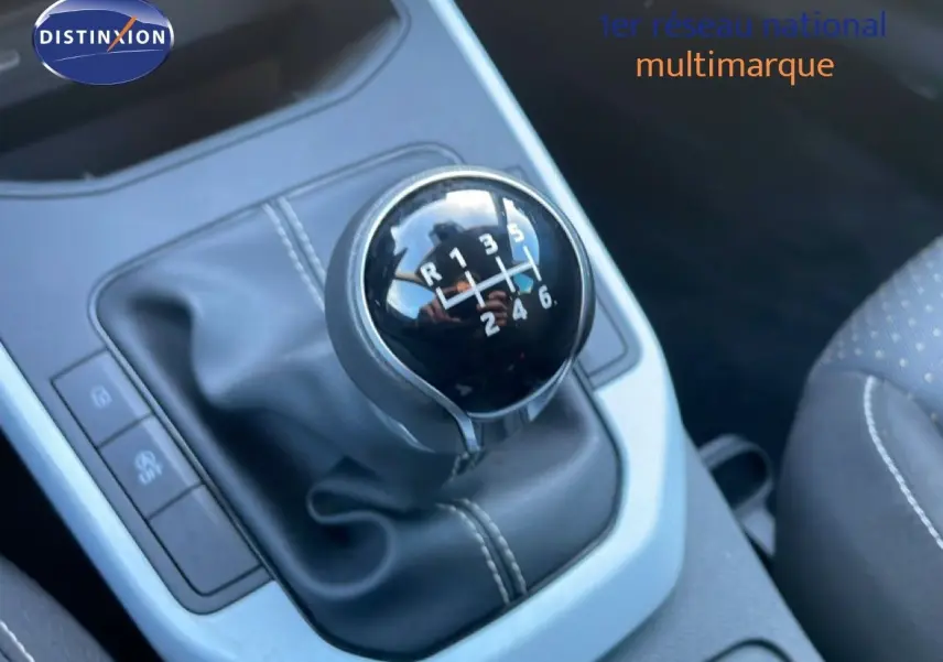 Gros plan sur le levier de vitesses manuel noir de la SEAT Arona 2025, intérieur tissu gris avec surpiqûres blanches.