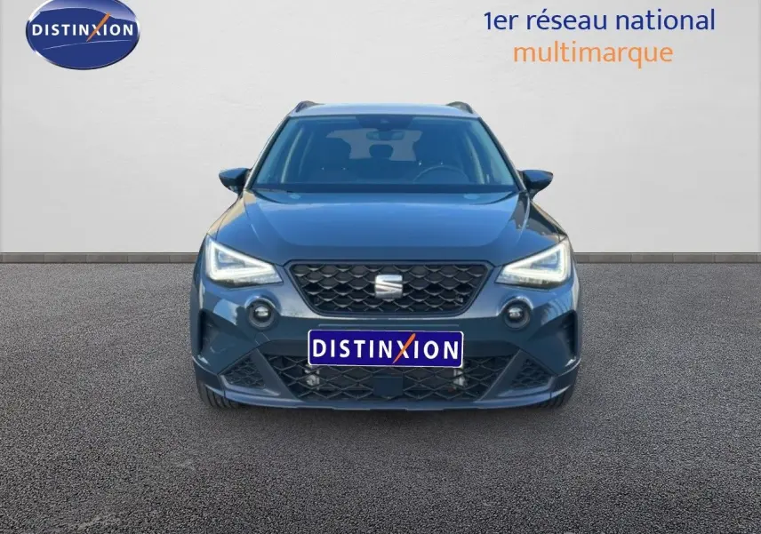 Vue frontale d'une SEAT Arona gris Fiord avec toit blanc, phares LED allumés sur fond neutre.