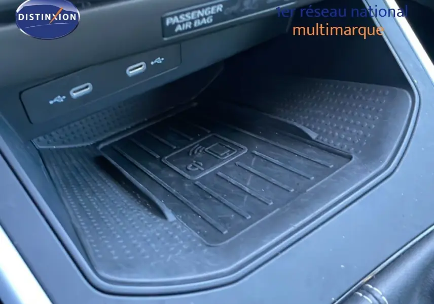 Gros plan sur la zone de recharge sans fil et ports USB dans l’habitacle noir du SEAT Arona gris fiord 2025.