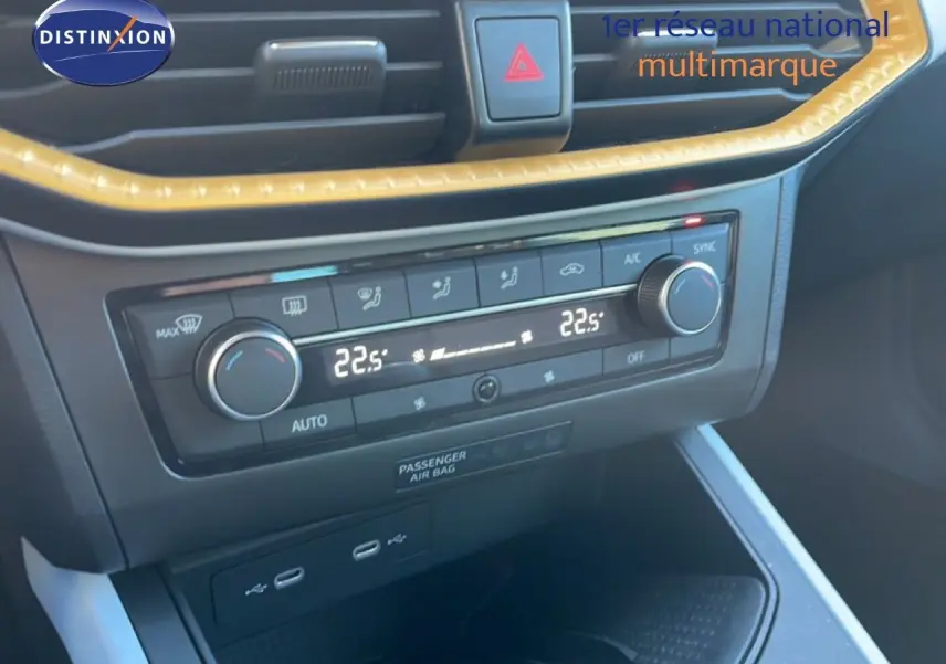 Vue rapprochée de la console centrale du SEAT Arona 2025, climatisation digitale affichant 22,5°C, finition gris et blanc.