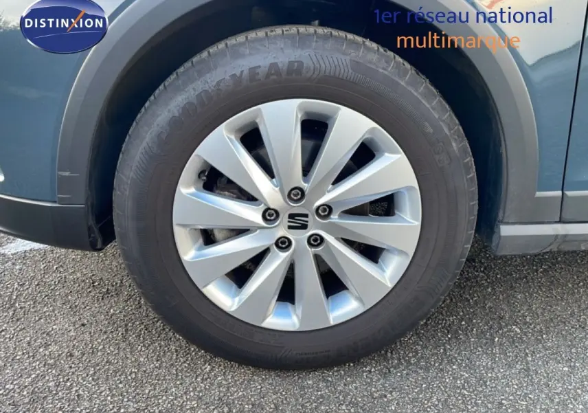 Gros plan sur la roue avant gauche d’un SEAT Arona gris Fiord avec jante argentée et logo central noir.