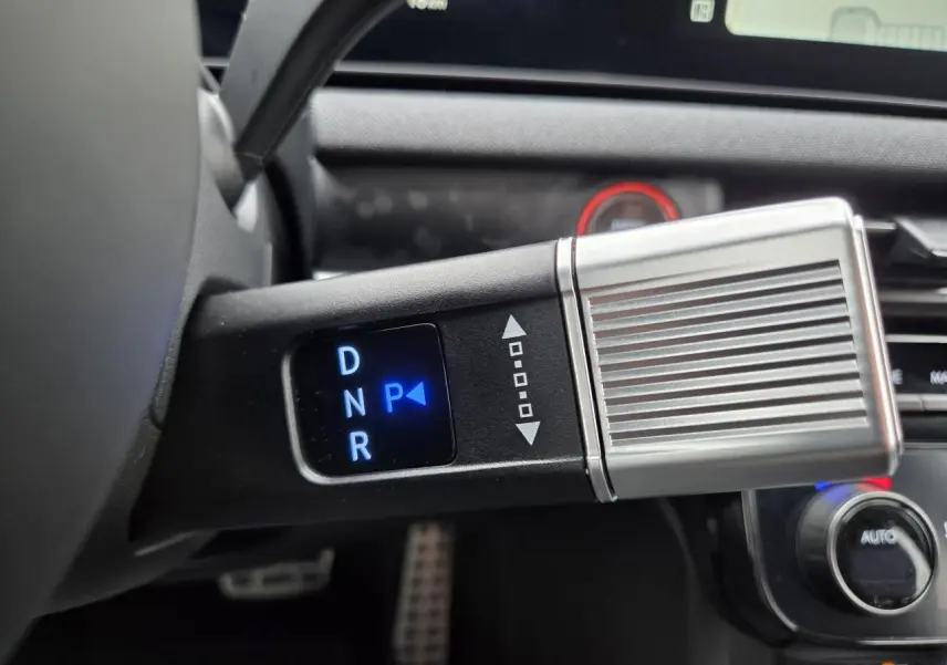 Gros plan sur la commande de boîte automatique avec indication lumineuse bleue sur mode parking dans un Hyundai Tucson gris.