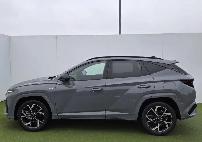 Vue de profil côté gauche du Hyundai Tucson 2025 gris métallisé Shadow Grey avec jantes alliage 19'' N Line distinctives.