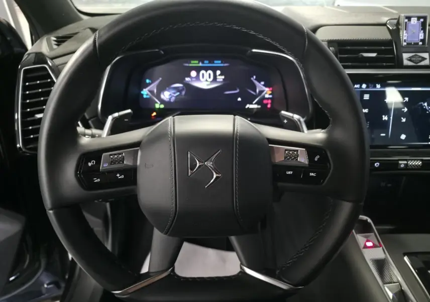Vue centrée sur le volant cuir noir du DS7 Crossback 2024 avec tableau de bord numérique et commandes intégrées.