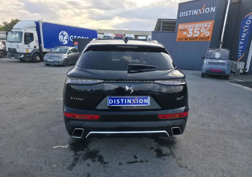 Vue arrière d'un DS7 Crossback E-Tense noir avec feux arrière 3D et double sorties d'échappement chromées.