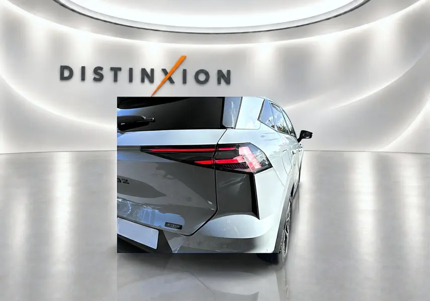 Vue arrière droite du Renault Symbioz gris rafale avec feux arrière LED et becquet distinctif dans un showroom lumineux.