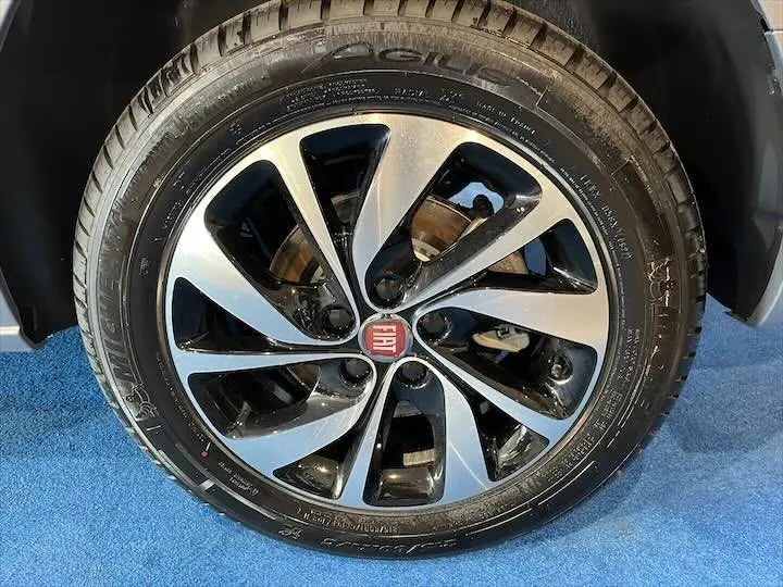 Gros plan sur la jante alliage noire et argentée avec logo FIAT au centre, montée sur pneu Michelin.