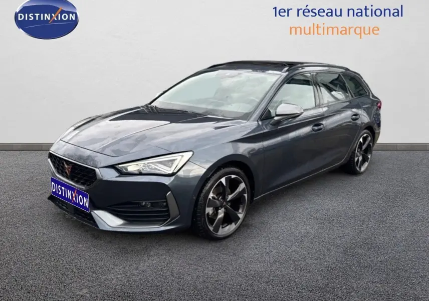 Vue 3/4 avant d'une CUPRA Leon ST 2024 gris magnétique métal avec jantes alliage bicolores et calandre distinctive.