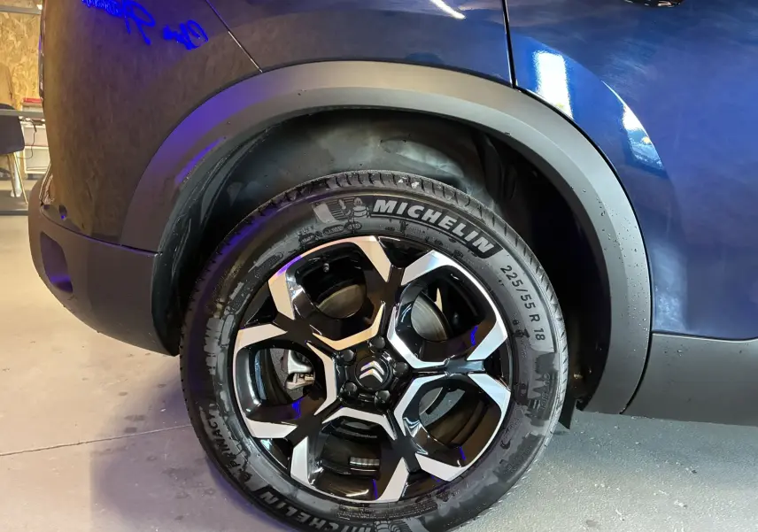 Détail de l'arrière droit d'un Citroën C5 Aircross bleu Eclipse Metal, mettant en valeur l'aile et la roue.