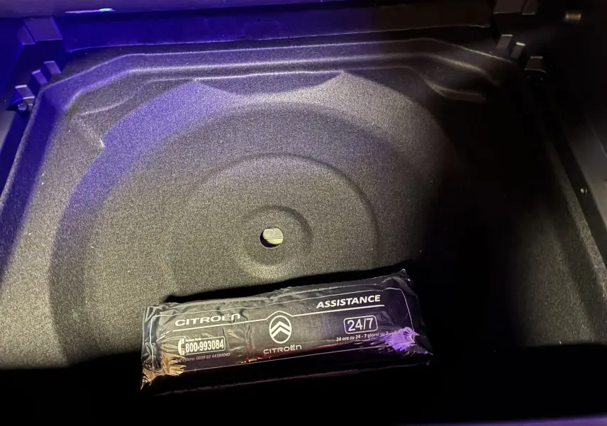 Gros plan sur le rangement sous le coffre du Citroën C5 Aircross bleu Eclipse Metal avec trousse d'assistance visible.