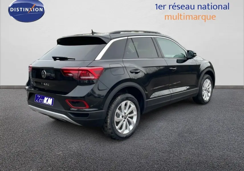 Vue 3/4 arrière droite d'un Volkswagen T-Roc noir Grenadilla métallisé avec jantes argentées et toit panoramique.