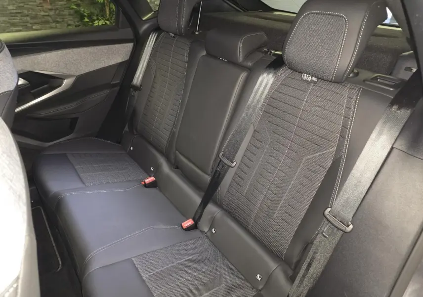 Vue intérieure du siège arrière droit du Peugeot 3008 1.2i Hybrid gris, avec sellerie tissu et cuir noir à surpiqûres claires.