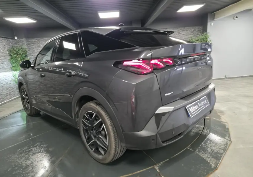 Vue 3/4 arrière droite du Peugeot 3008 gris métallisé 2025 avec feux arrière LED griffés et jantes alliage noires.