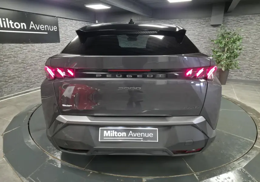 Vue arrière d'un Peugeot 3008 gris métallisé avec feux arrière à griffes LED et bandeau noir laqué lumineux.