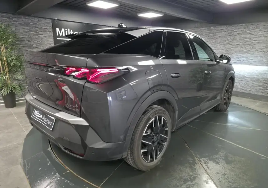 Vue 3/4 arrière droit du Peugeot 3008 gris métallisé avec feux arrière LED griffés et jantes alliage noires.