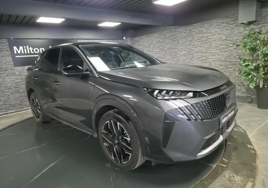 Peugeot 3008 gris métallisé en 3/4 avant droit, avec calandre noire et jantes alliage 19 pouces diamantées.