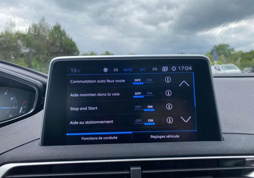 Écran tactile central du Peugeot 3008 blanc 2019 montrant les réglages d’aides à la conduite par temps couvert.