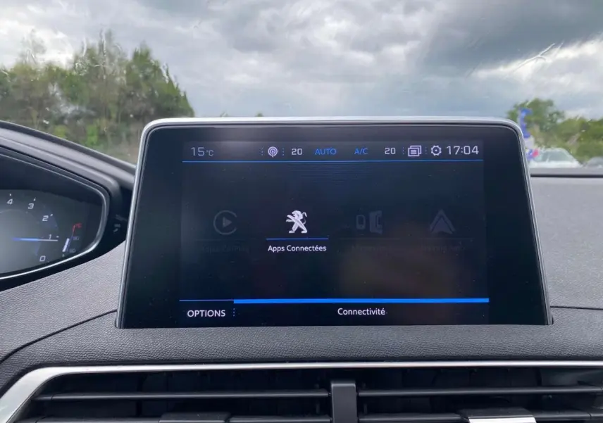 Vue intérieure centrée sur l'écran tactile du tableau de bord du Peugeot 3008, affichant les apps connectées.