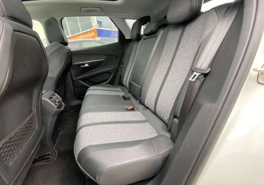 Vue intérieure côté droit des sièges arrière bi-matière tissu gris et cuir noir du Peugeot 3008 blanc avec toit ouvrant panoramique.