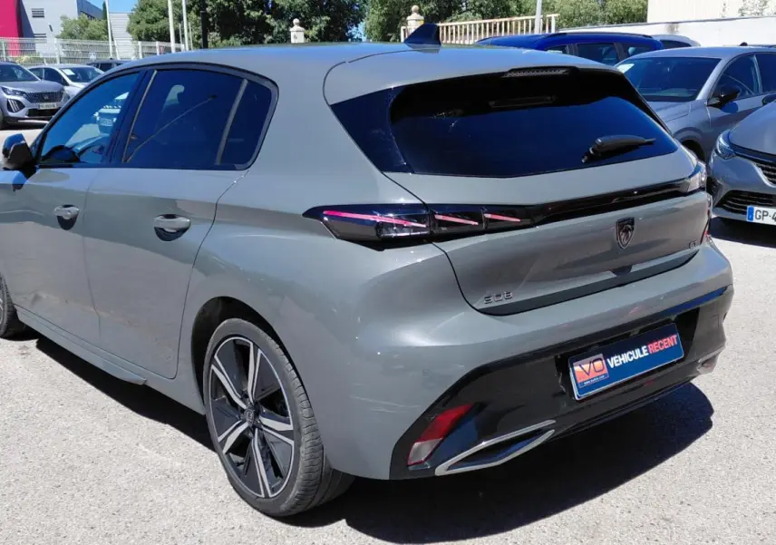Vue 3/4 arrière droite d’une Peugeot 308 Hybrid 145 gris avec jantes alliage 18 pouces et feux arrière LED.