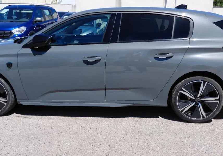 Vue de profil côté gauche d'une Peugeot 308 Hybrid 145 e-DCS6 GT gris avec jantes alliage 18 pouces.