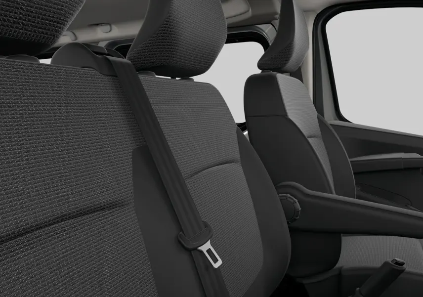 Gros plan sur les sièges avant gris tissu du Renault Trafic Combi 2026, avec ceinture de sécurité et accoudoir côté droit.