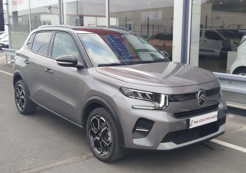 Citroën C3 2025 gris foncé avec toit noir, vue 3/4 avant droit, feux LED et jantes bi-ton distinctives.