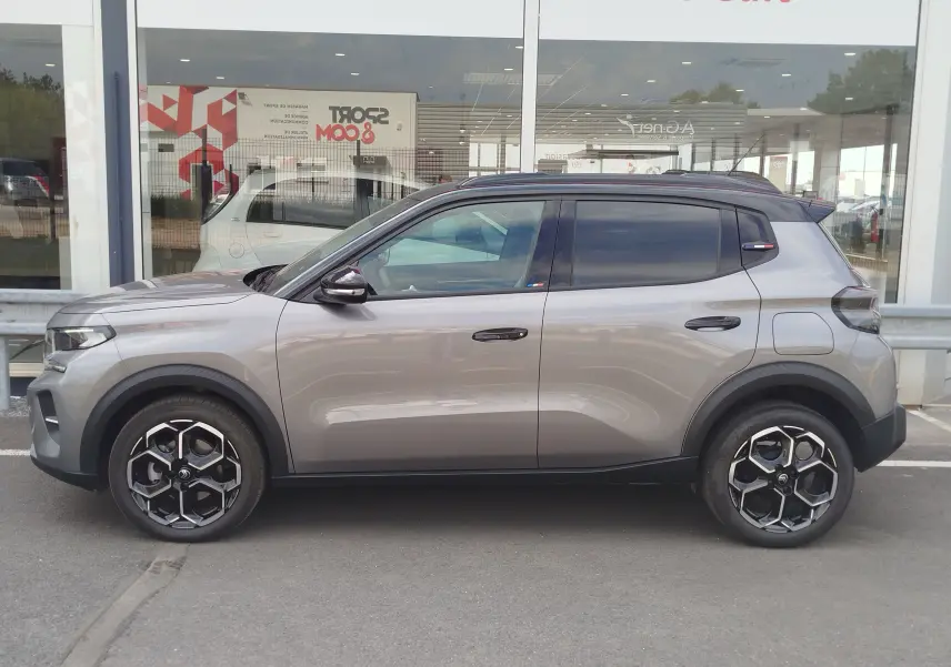 Citroën C3 2025 gris foncé avec toit noir, vue de profil côté gauche, jantes alliage noires et détails noirs contrastants.
