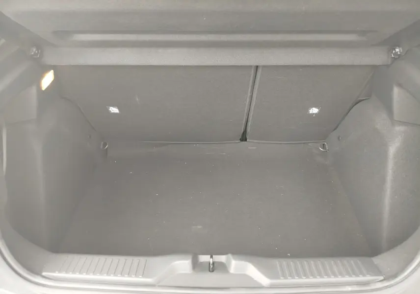 Coffre vide en tissu noir de la Citroën C3 1.2 Turbo 100ch MAX 2025, vu de l'arrière avec éclairage intérieur allumé.