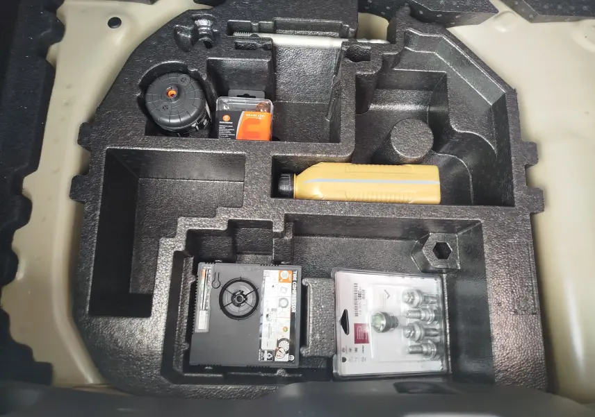 Rangement sous coffre de la Citroën C3 2025, compartiments en mousse noire avec kit de réparation pneus et accessoires.