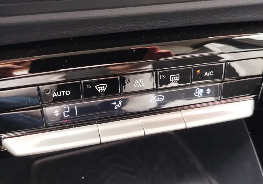 Détail du tableau de bord de la Citroën C3 2025, montrant les commandes de climatisation automatique à 21°C.