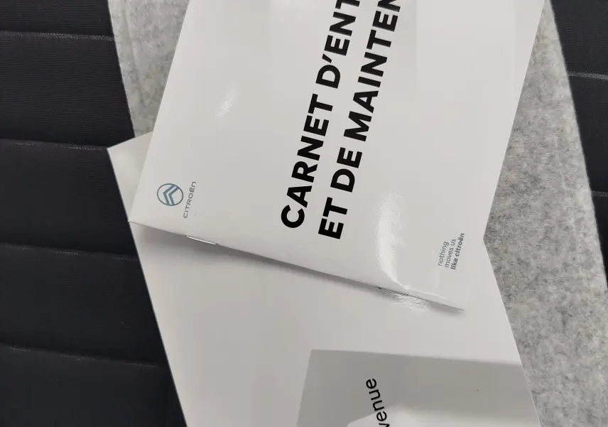 Image montrant deux brochures Citroën C3 posées sur un siège noir, sans vue du véhicule lui-même.